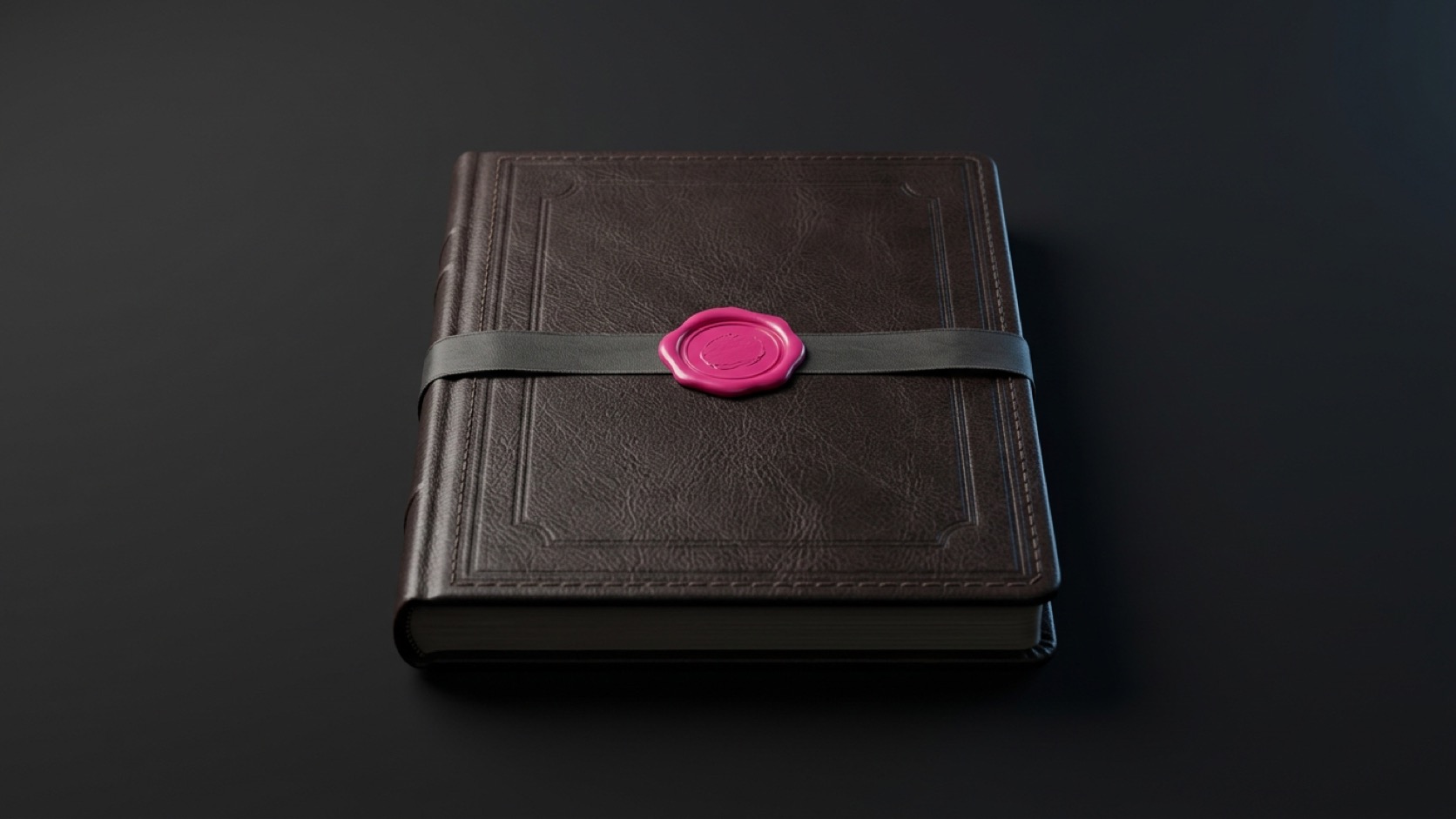 A closed leather ledger sealed with a vivid pink wax seal on a dark graphite studio surface